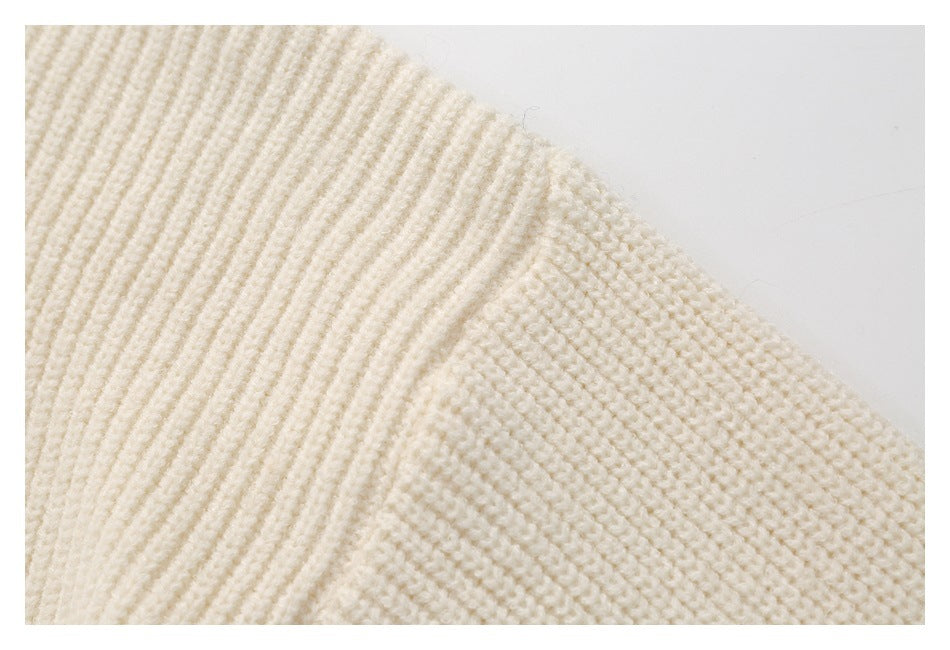 Close-up of the ivory sweater’s ribbed sleeve transitioning into textured knit at the shoulder.