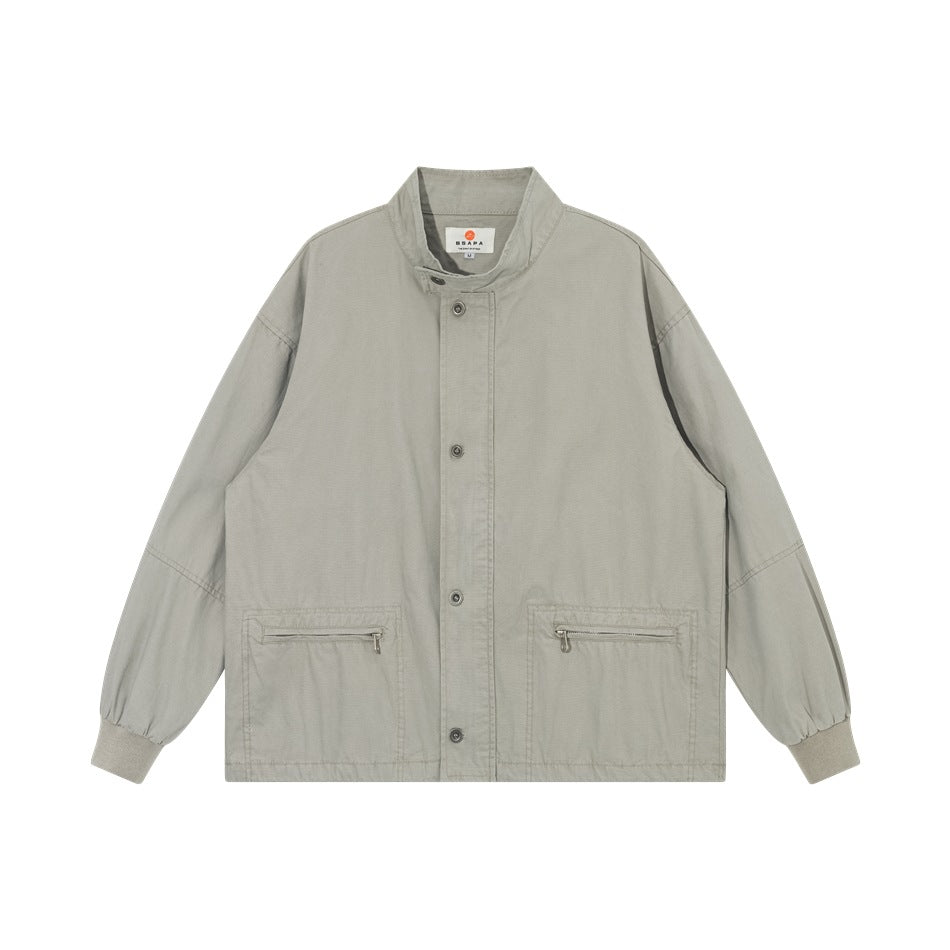 Light gray stand-collar jacket with button front, two zippered pockets and ribbed cuffs, flat lay front view