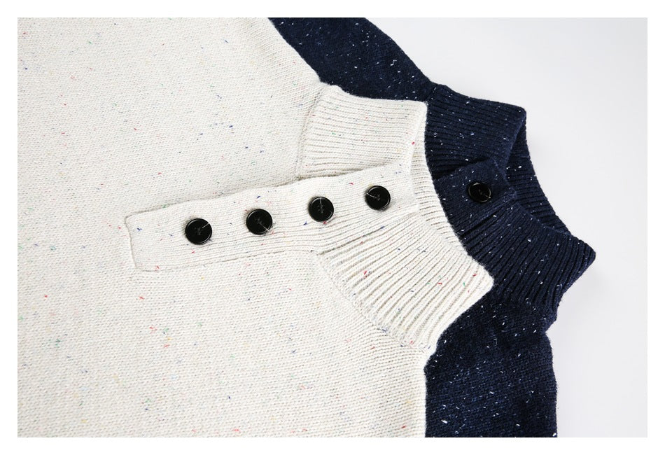 Close-up of cream and navy speckled knit sweater collars with ribbed edges and black buttons.