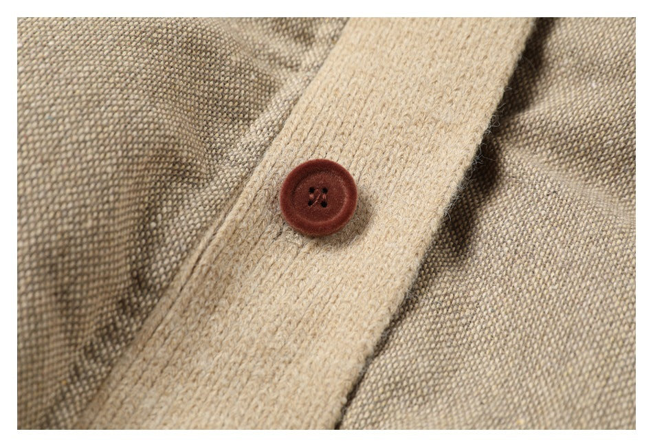 Close-up of a reddish-brown four-hole button on the jacket's light ribbed placket.