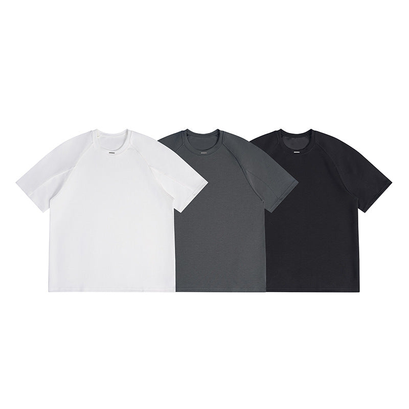 Three short-sleeve raglan crew-neck T-shirts shown together in white, charcoal gray, and black.