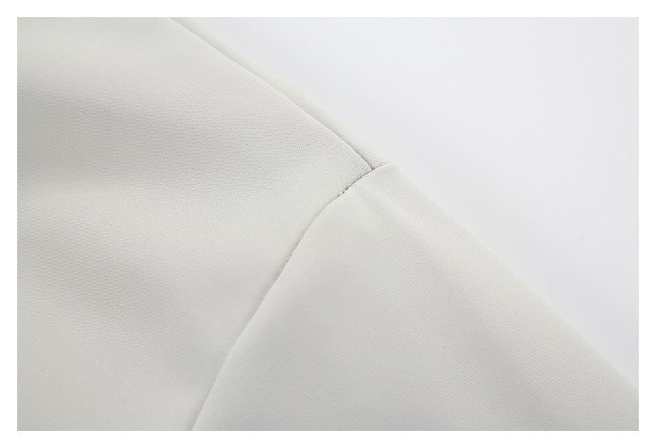 Close-up of a light gray garment seam against a plain white background.