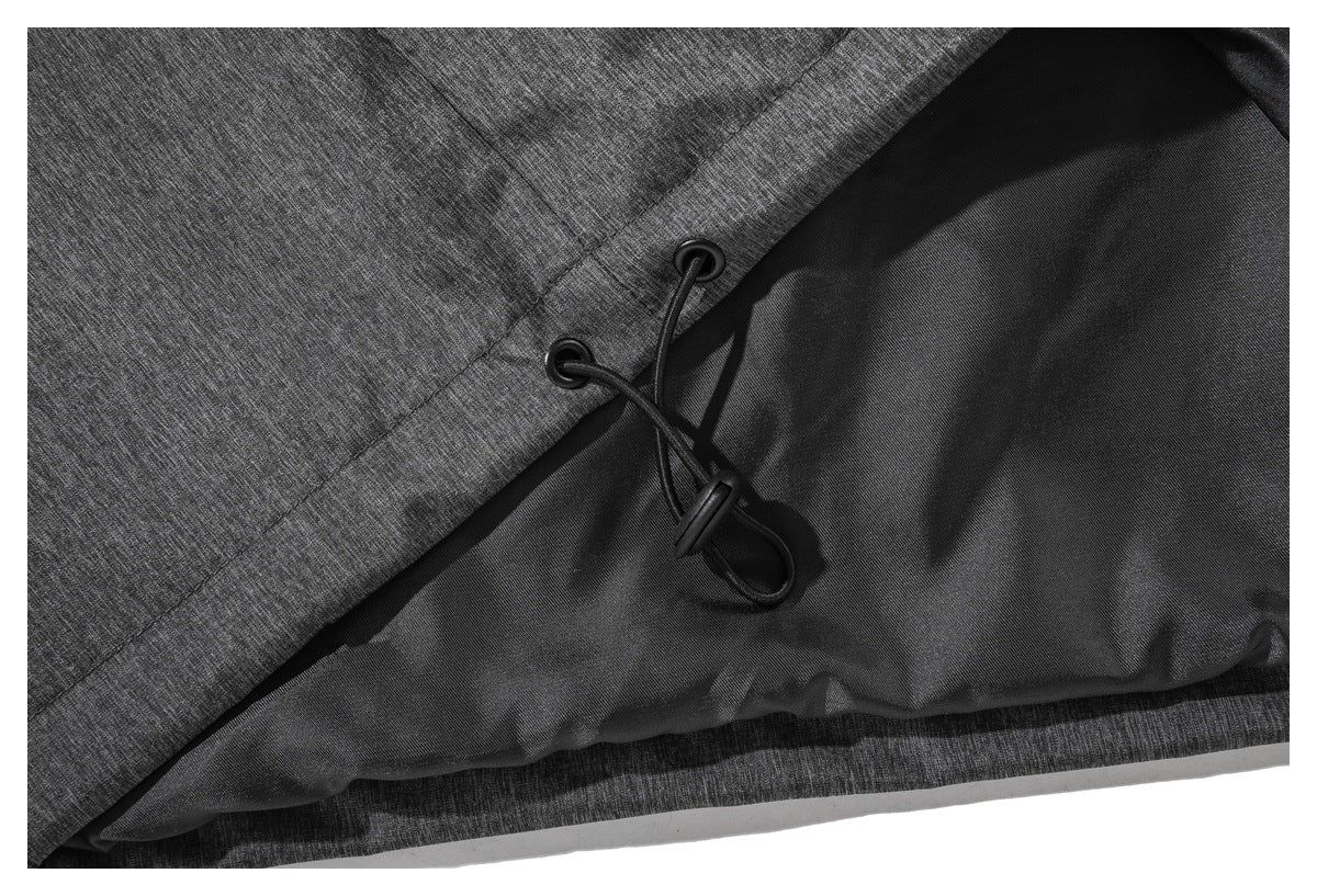 Close-up of a charcoal heather jacket hem with black elastic drawcords and cord locks.