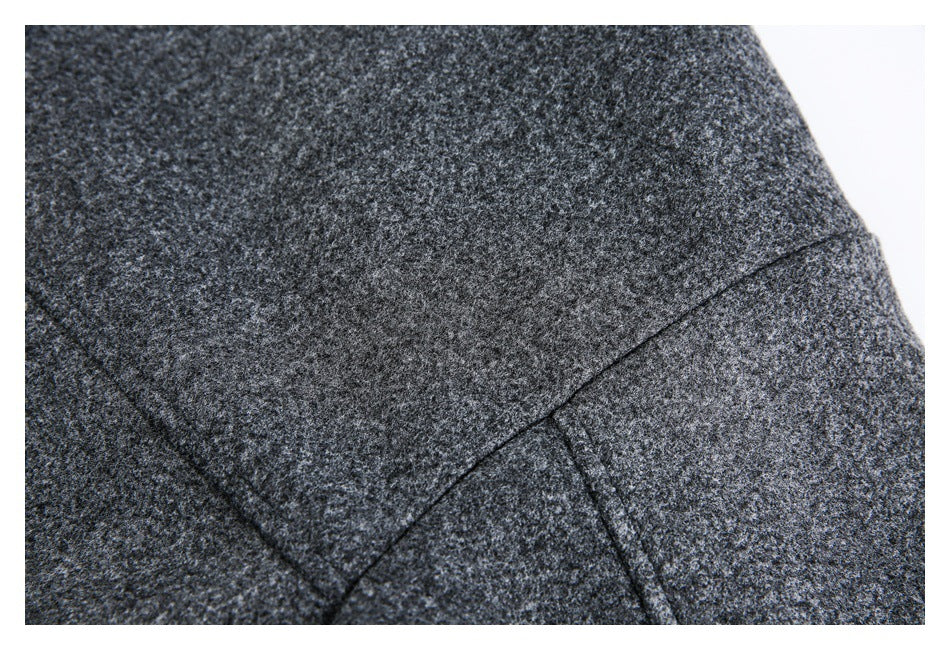 Close-up of intersecting seams on a dark charcoal heathered garment.