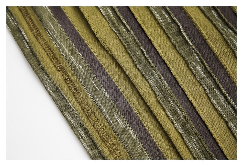 Close-up of an overlocked edge and seams on olive, brown, and textured green striped fabric.