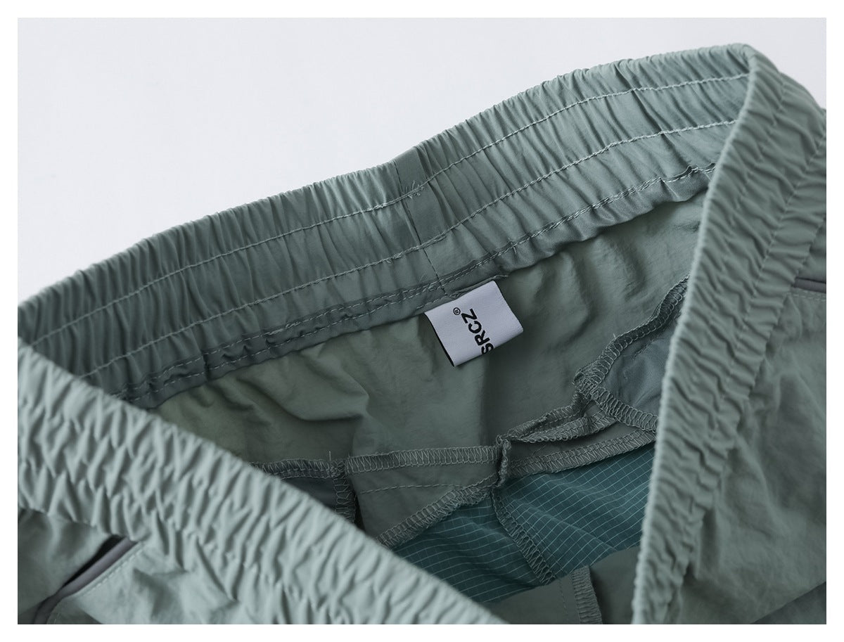Inside view of sage green pants showing waistband stitching, overlocked seams, and a sewn-in label.