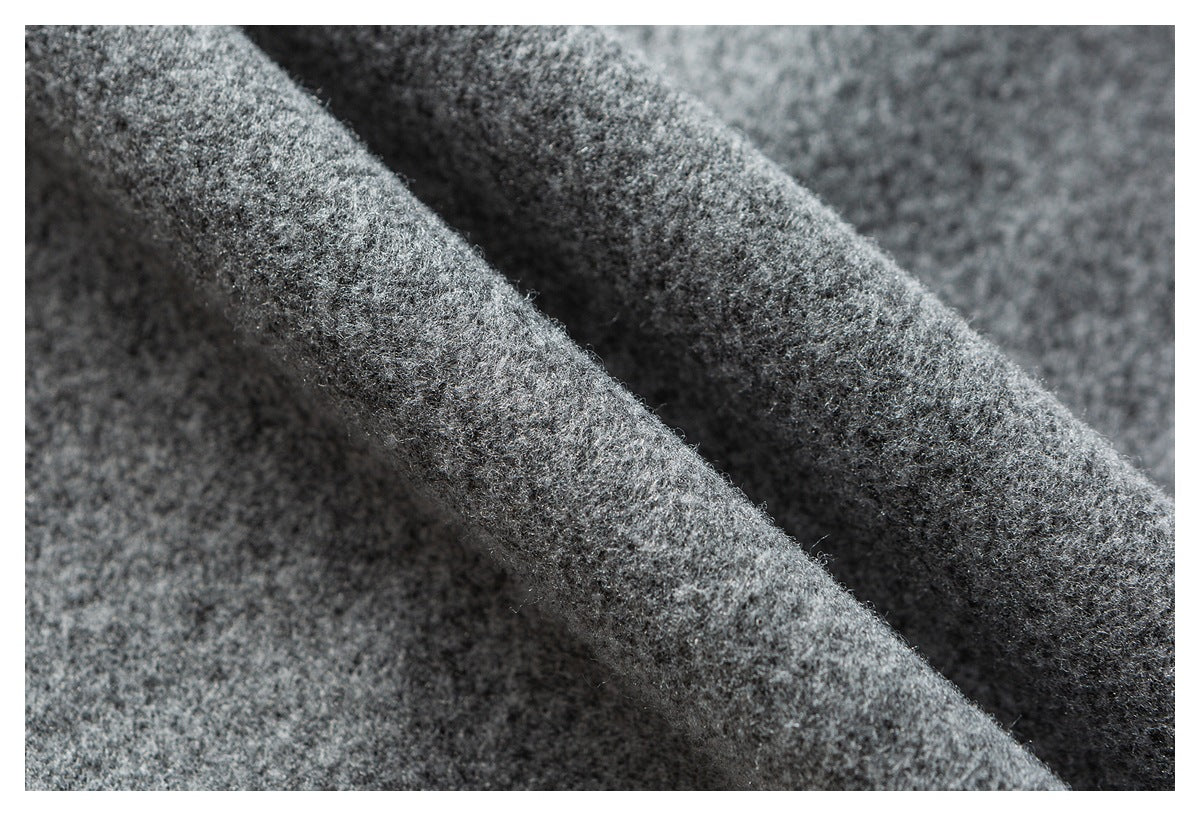 Close-up of gray fuzzy fabric draped in folds, showing its soft-looking surface.