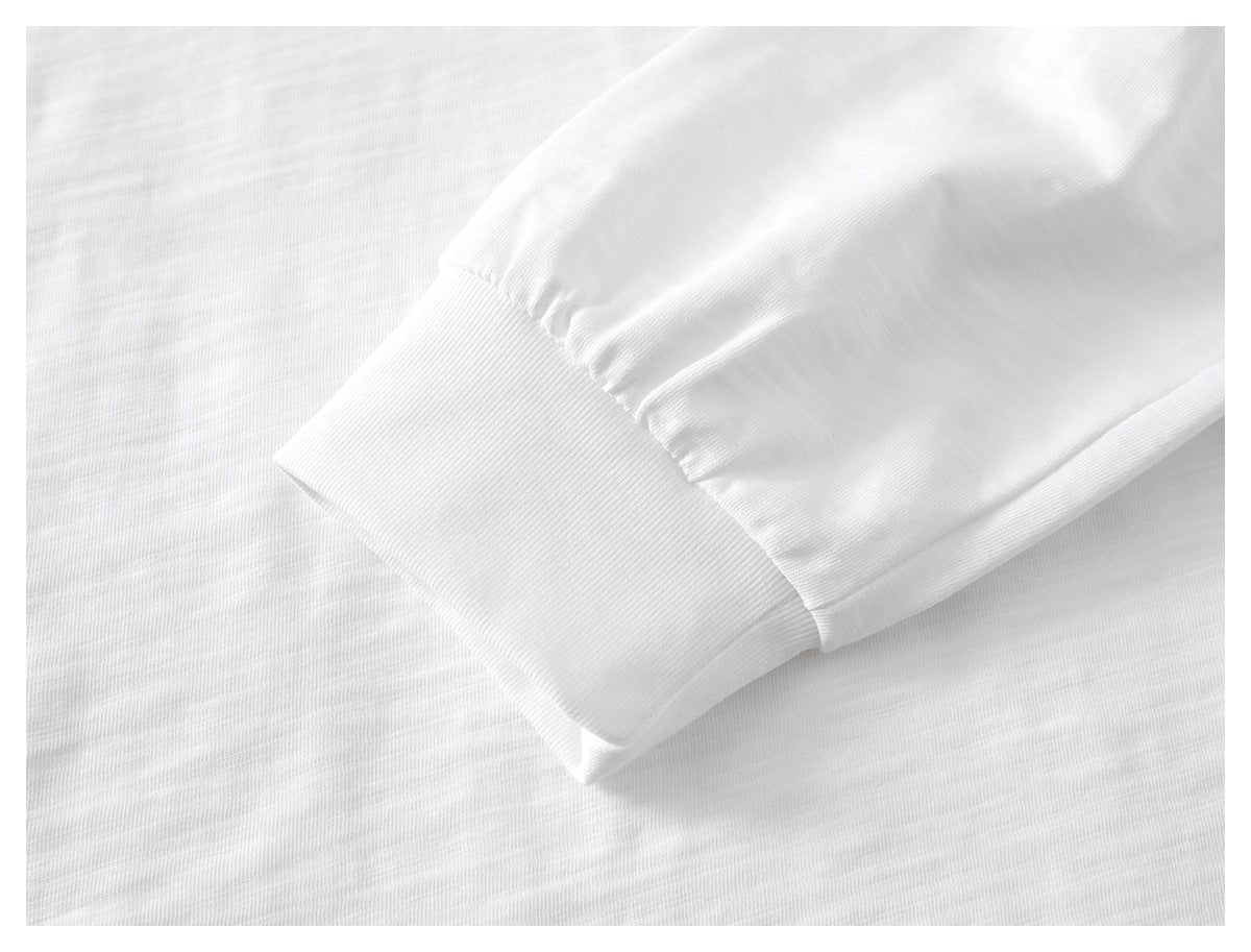 Close-up of the ribbed cuff on a white T-shirt sleeve.