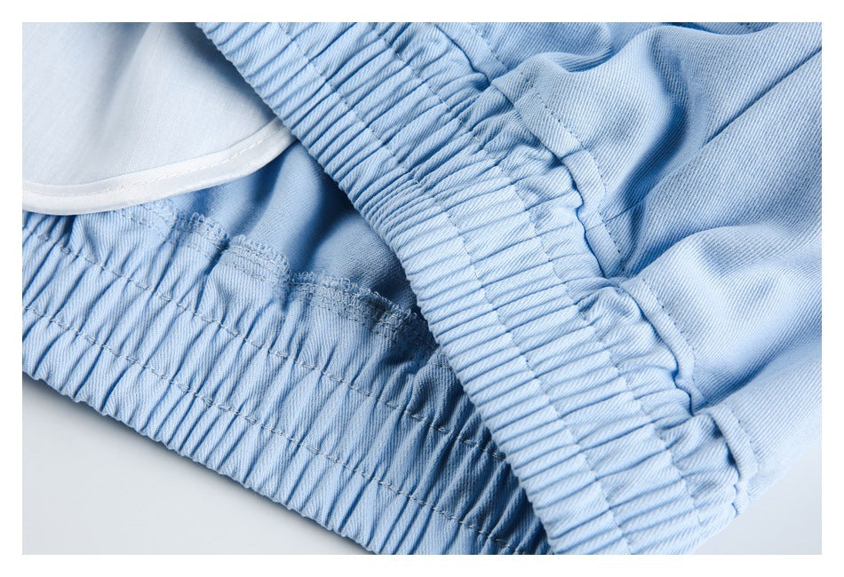 Close-up of a light blue garment’s gathered elastic waistband and stitched seams.