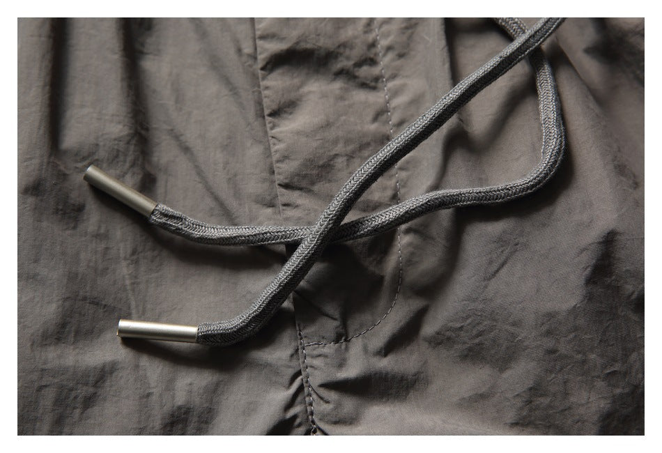 Close-up of the gray drawstrings with metal tips against the shorts.