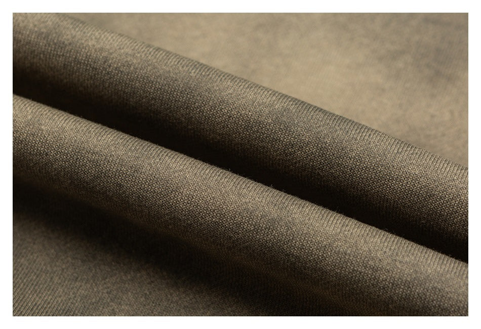 Macro view of taupe-brown fabric folded into ridges, showing its fine textured surface.