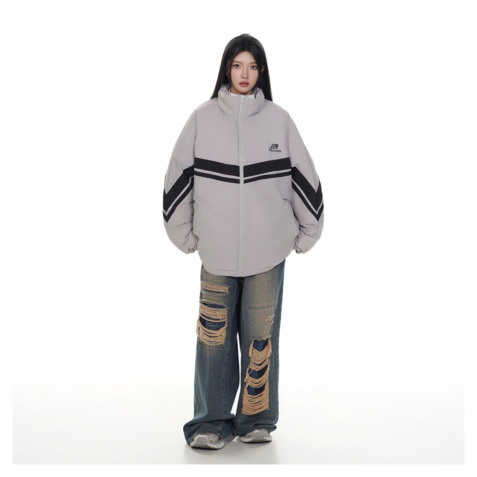 Full-length model wearing a light gray oversized zip jacket with black chevron stripes and distressed wide-leg jeans.