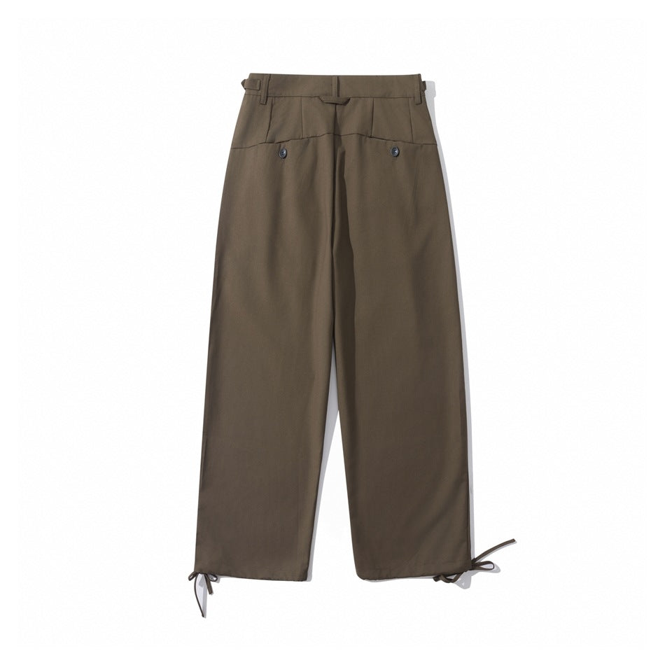 Back view of brown wide-leg trousers with a high waistband, two buttoned pockets, and adjustable hem ties.