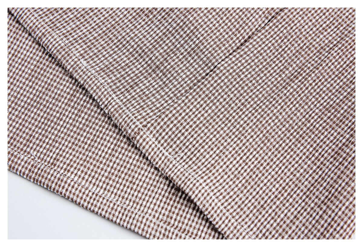 Close-up of a folded seam on brown-and-white small-check fabric.