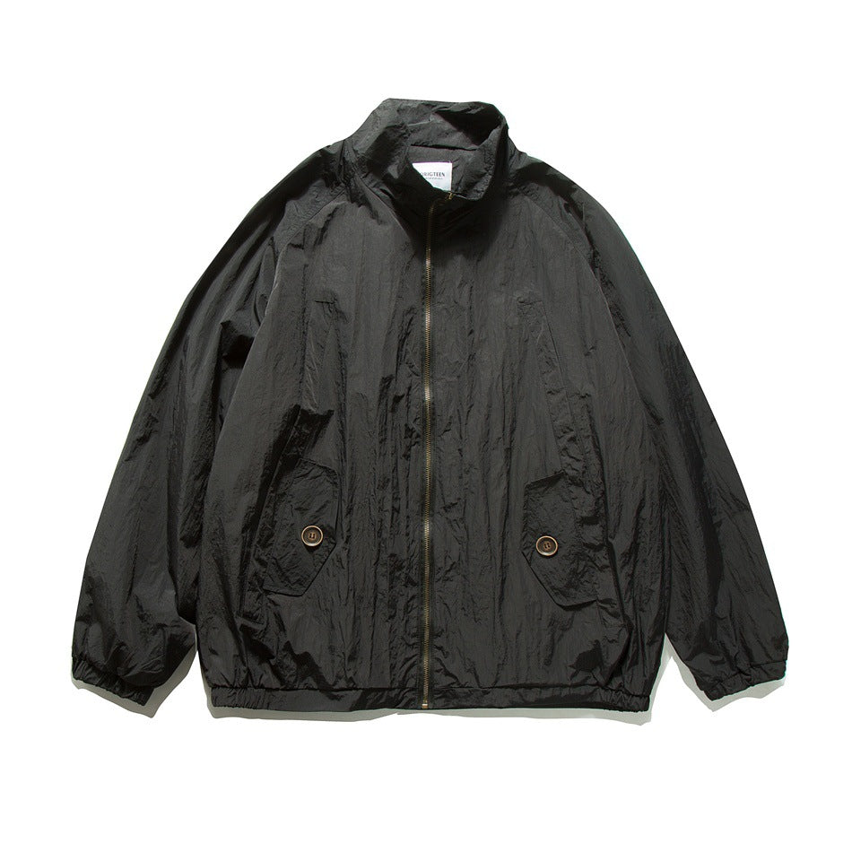 Black zip-up jacket with stand collar, button flap pockets and elastic cuffs, flat front view