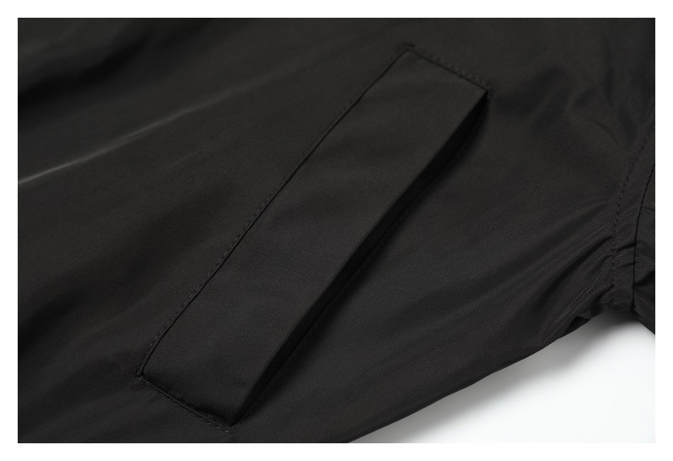 Close-up of a long, angled pocket opening on black jacket fabric.