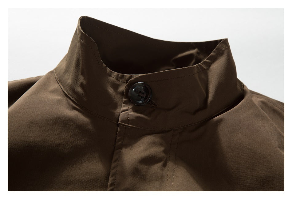 Close-up of a dark brown jacket's stand collar, front button, and stitched placket.