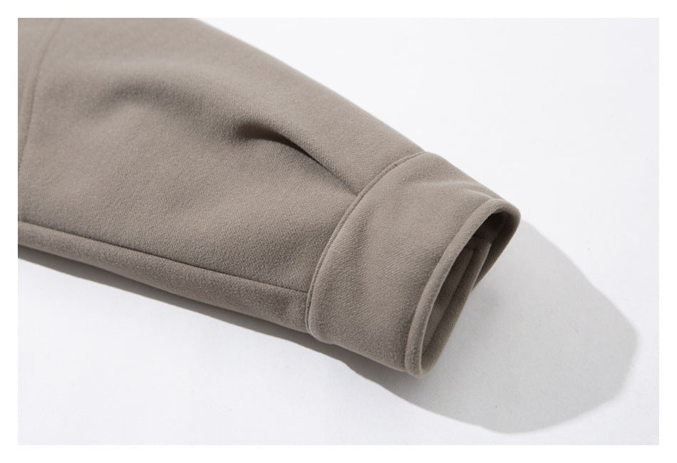 Close-up of a taupe jacket sleeve ending in a wide cuff.