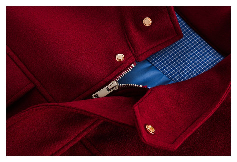 Close-up of a burgundy coat's front zipper, snap fasteners and blue checked inner lining.