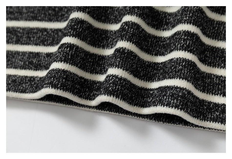 Close-up of wavy charcoal and cream knit stripes, showing the fabric texture.
