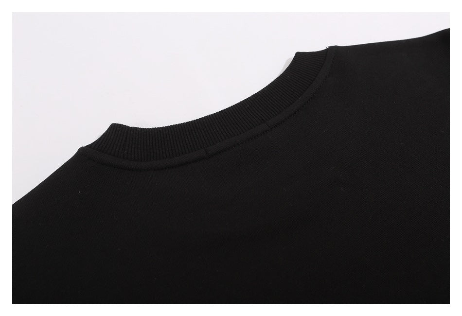 Close-up of the black sweatshirt’s ribbed crew neckline and shoulder seam.