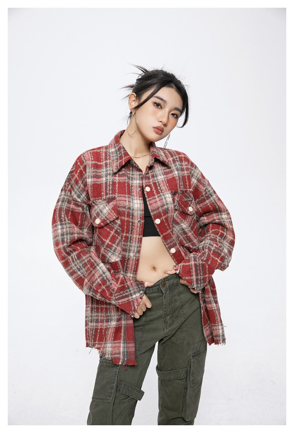 Model wearing the red plaid shirt-jacket open over a black top and green cargo pants