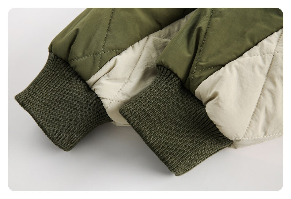Close-up of two olive ribbed cuffs and cream-and-olive quilted jacket sleeves.