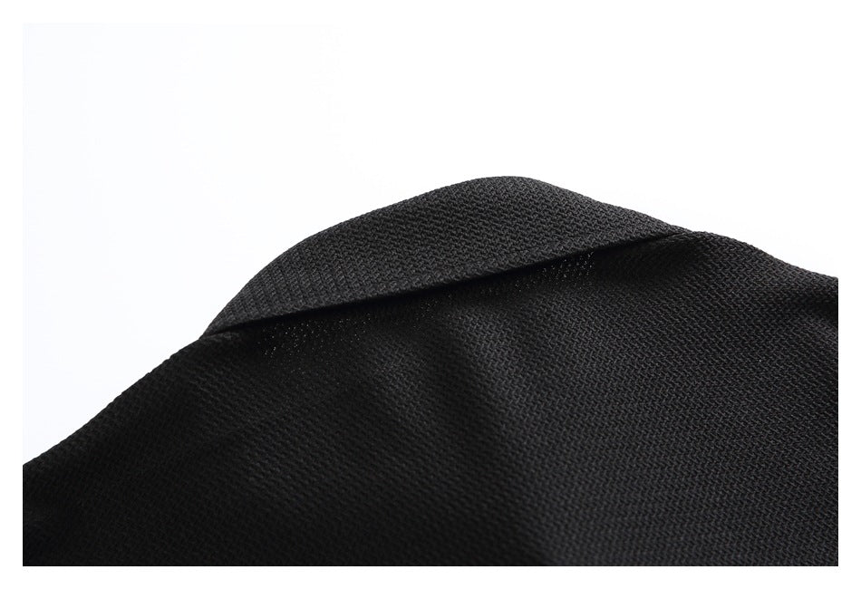 Close-up of a folded edge and textured surface on a black garment.
