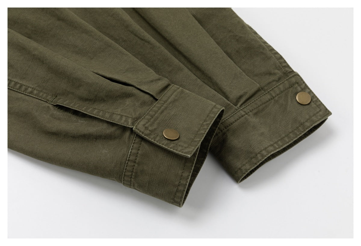 Close-up of olive drab sleeves with buttoned cuffs and brass-tone snap buttons.