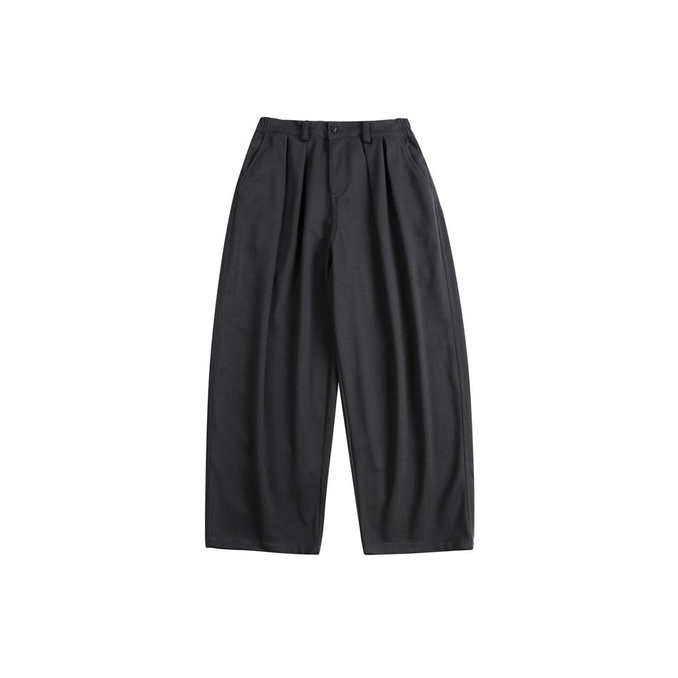 Dark charcoal gray wide-leg pleated trousers laid flat, front view with button, belt loops and side pockets