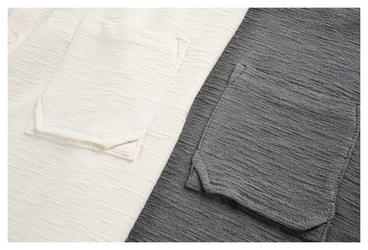 Close-up of patch pockets on cream and charcoal gray textured knit shirts.