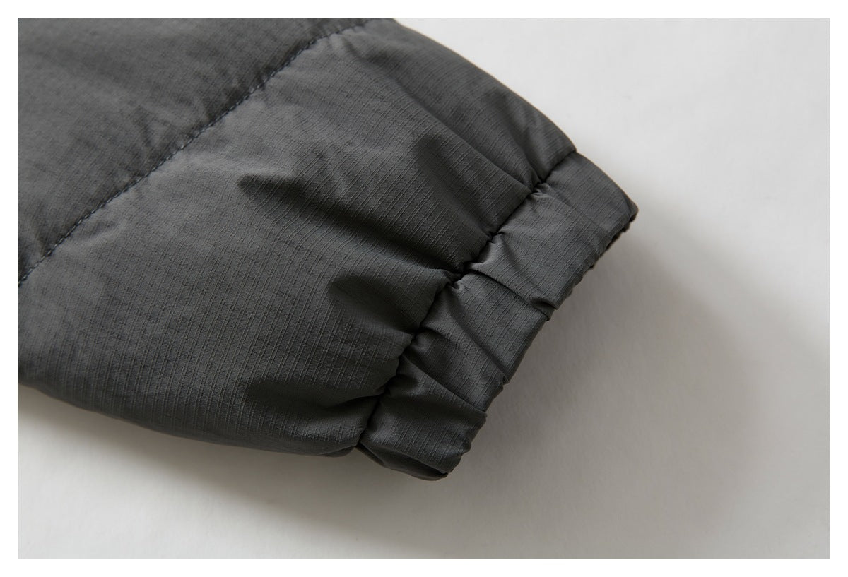 Close-up of a dark gray jacket sleeve ending in a gathered cuff.