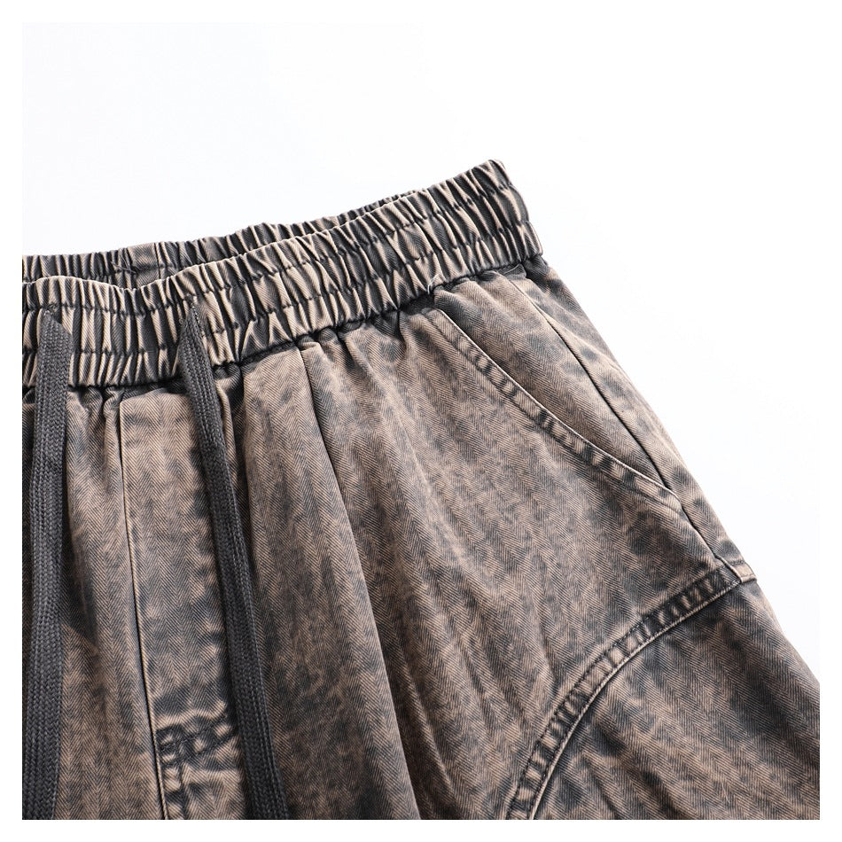 Close-up of the pants' gathered waistband, black drawstring, angled pocket opening, and curved lower panel seam.