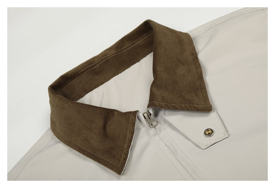 Close-up of an ivory jacket collar with a brown corduroy collar and metal zipper pull.