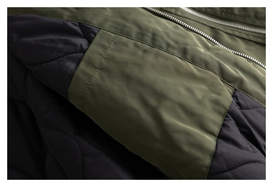 Close-up of an olive jacket panel over black quilted lining, with a silver zipper.