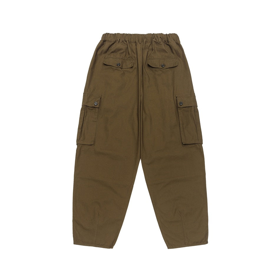 Rear view of brown cargo pants with an elastic waist and button-flap back and side pockets.