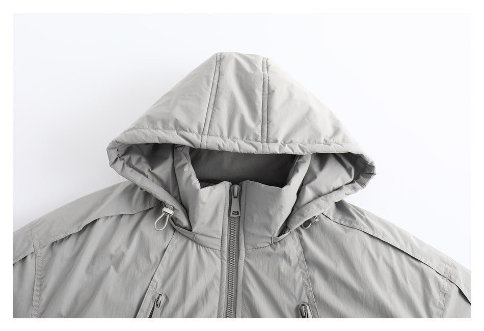 Close-up of a light gray jacket front with the hood raised, a high collar, center zipper, and drawcord toggles.