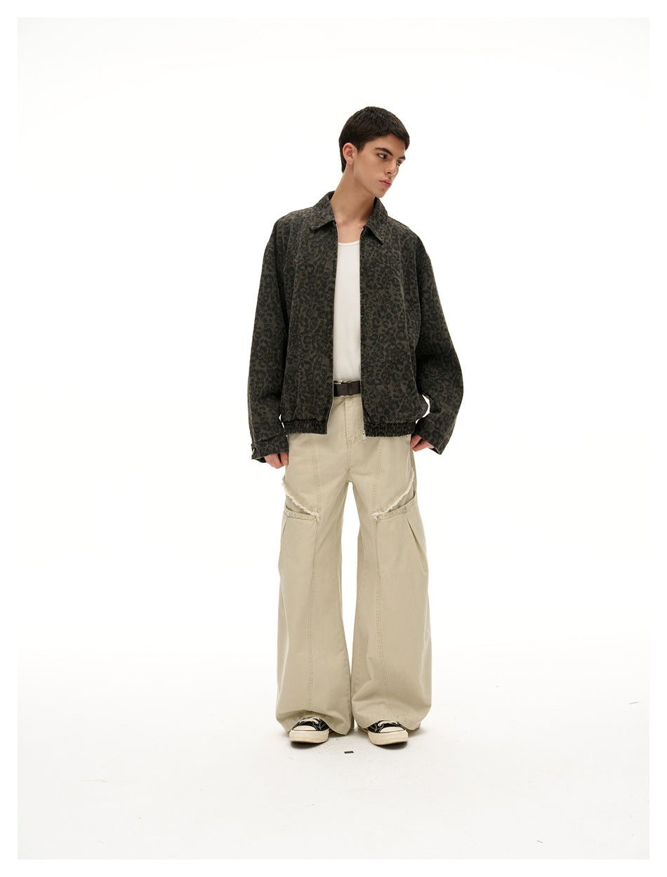 Model wearing a dark gray leopard-print zip jacket with a white shirt and loose beige pants.