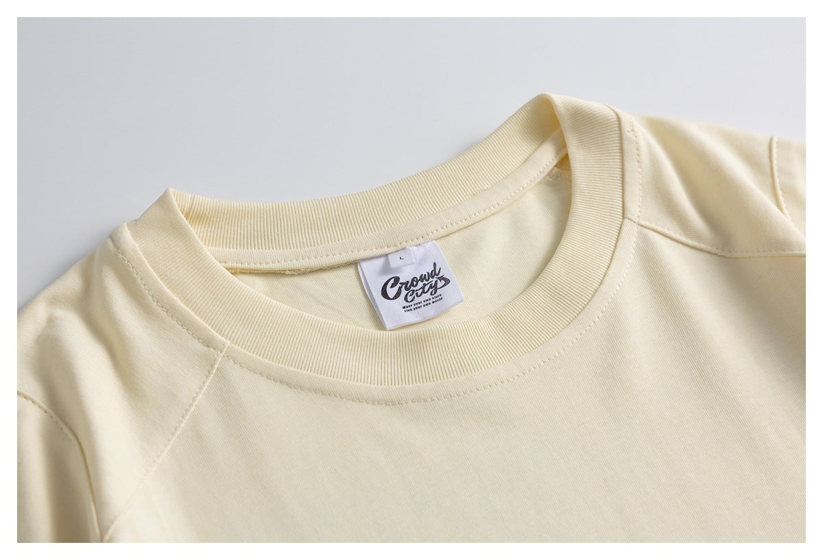 Close-up of a cream T-shirt’s ribbed crew neck and sewn-in neck label.