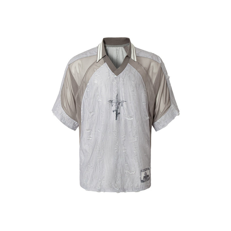 Front view of a pale gray textured short-sleeve shirt with taupe panels, striped collar, V-neck trim and chest graphic.