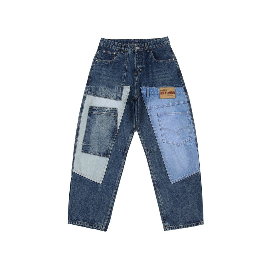 Front view of dark blue jeans with a relaxed tapered fit and contrasting light and medium blue denim patch panels.