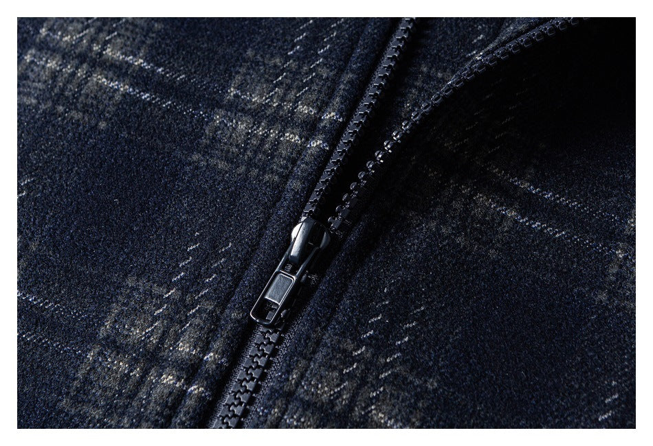 Close-up of a black zipper on dark navy plaid fabric.