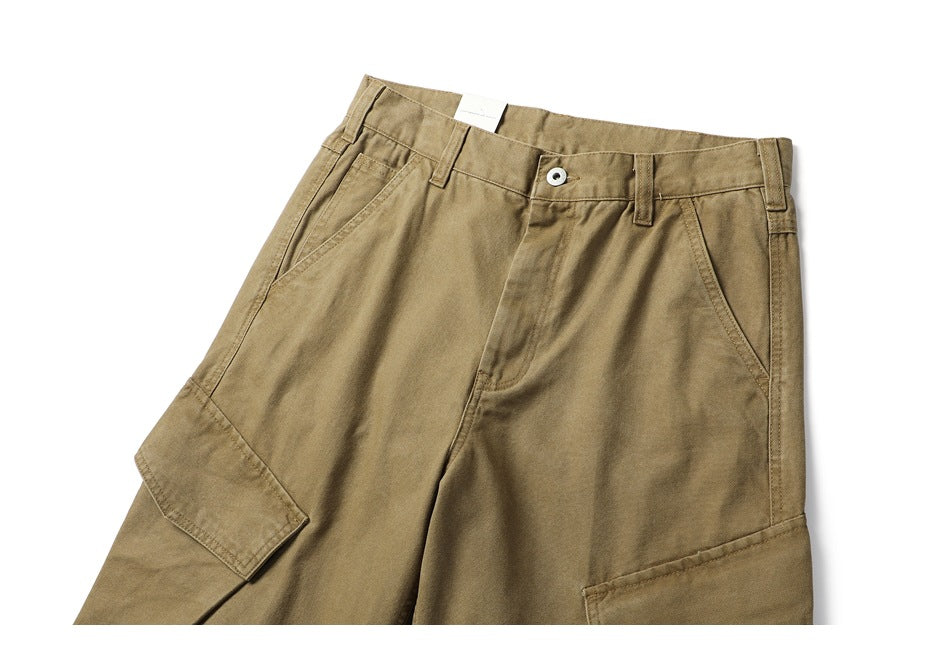 Front view of khaki cargo trousers with angled pockets, belt loops, a button closure and large leg pockets.