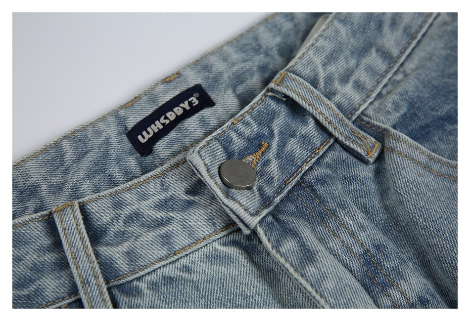 Close-up of the jeans' waistband, belt loop, metal button, and sewn-in brand label.