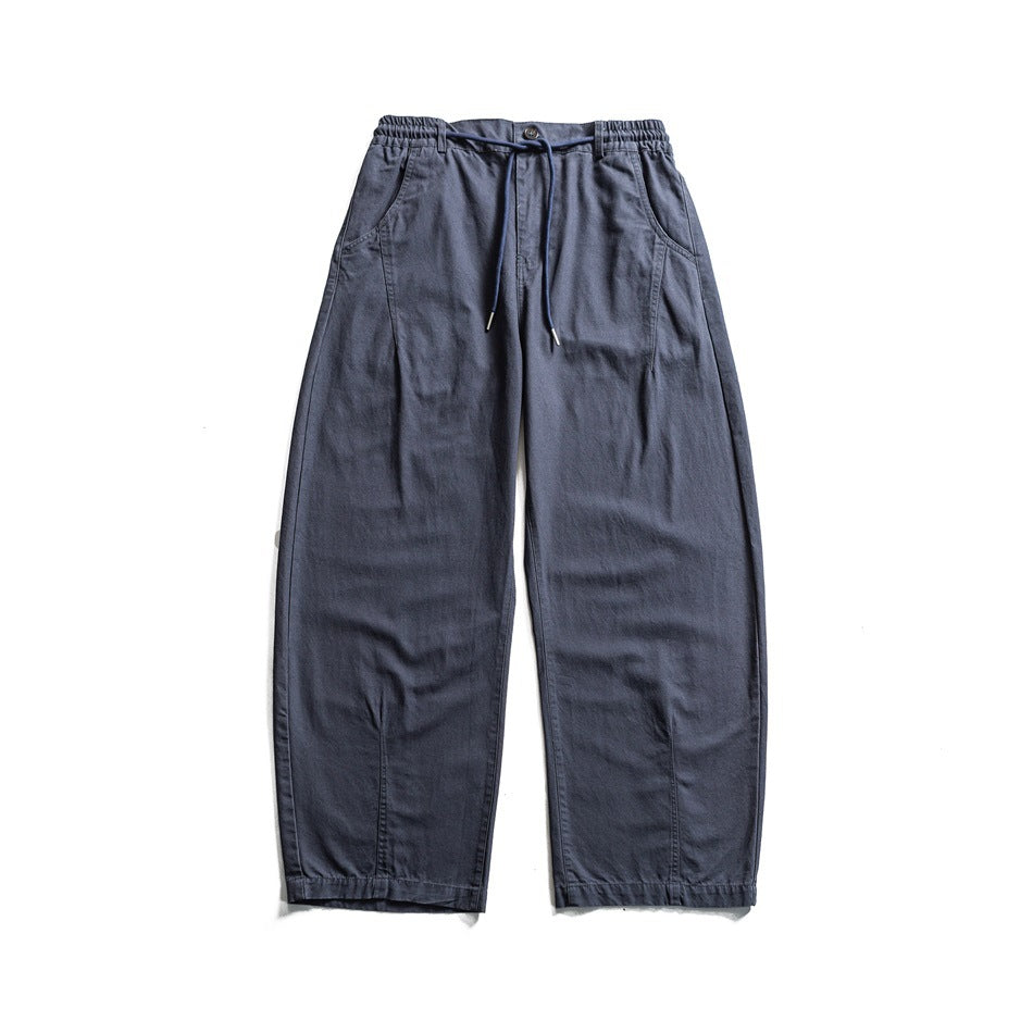 Front flat lay of slate-blue wide-leg pants with an elasticated waistband, drawstring, button, and side pockets.