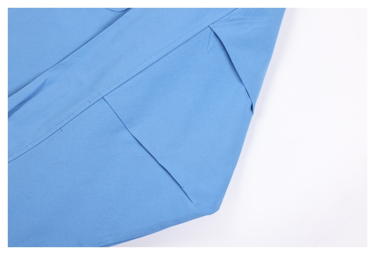 Close-up of a light blue shirt's side seam and underarm stitching.