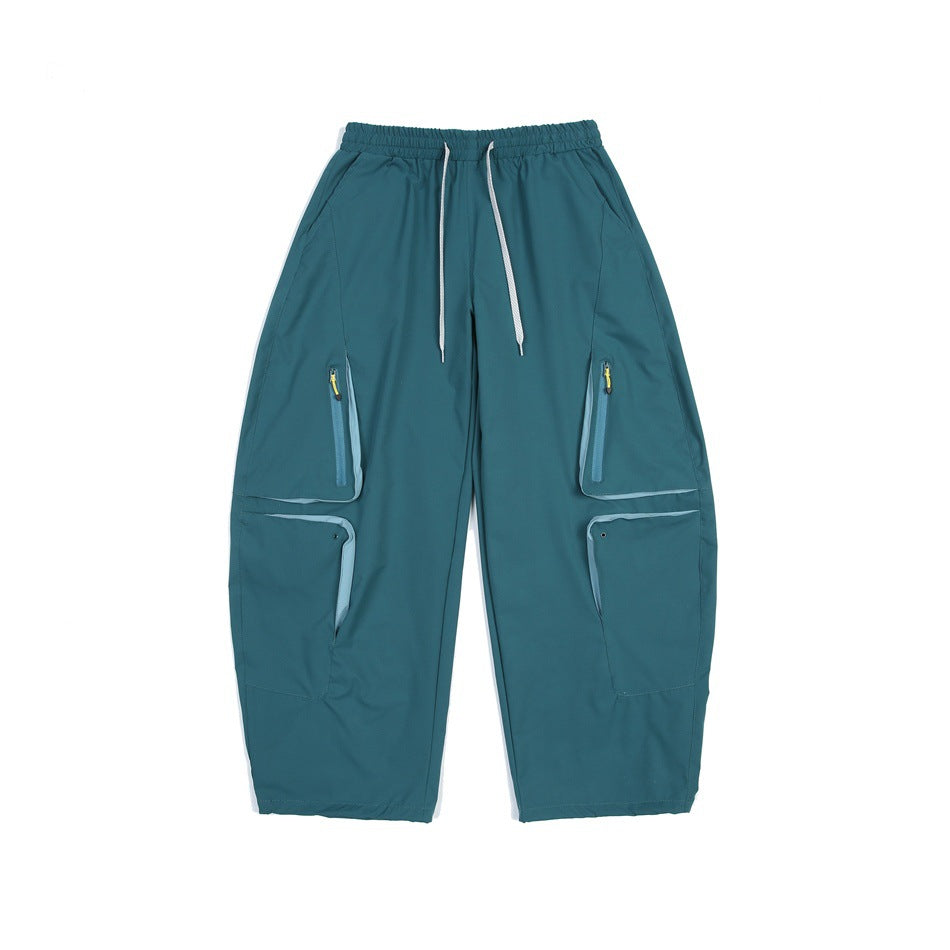 Teal green wide-leg cargo pants with white drawstring, yellow zipper pulls and flap pockets, front flat view