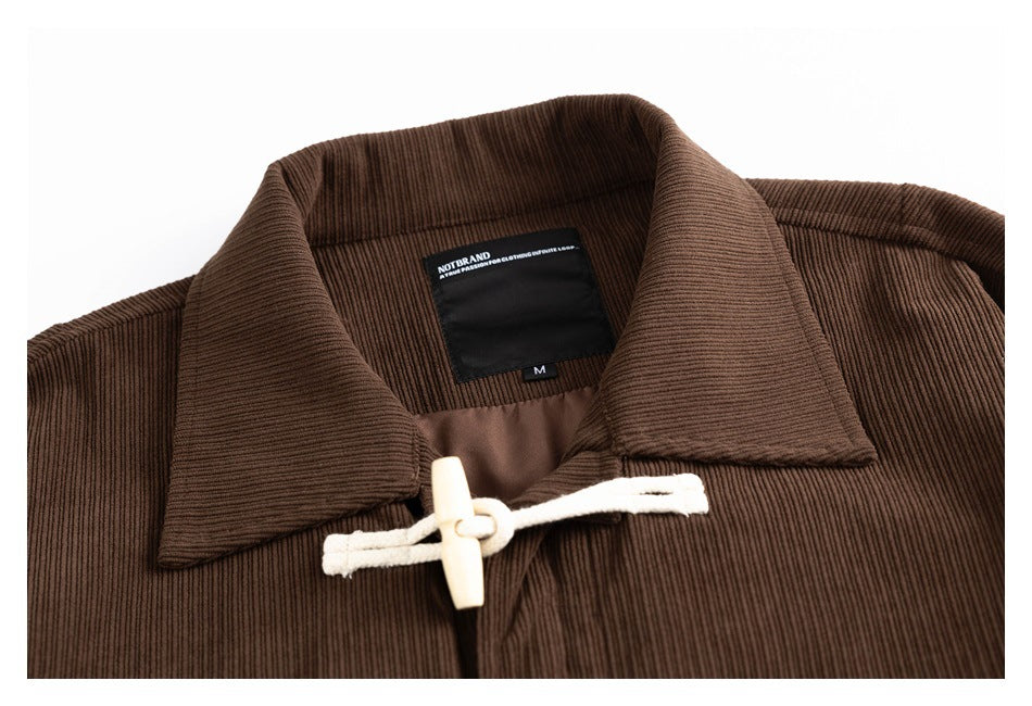 Cropped front view of a brown ribbed jacket with a wide collar and cream toggle closure.