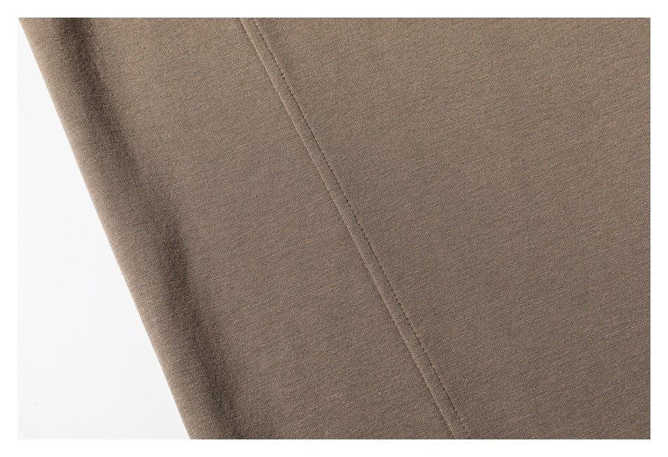 Close-up of taupe sweatshirt fabric and a long stitched seam.