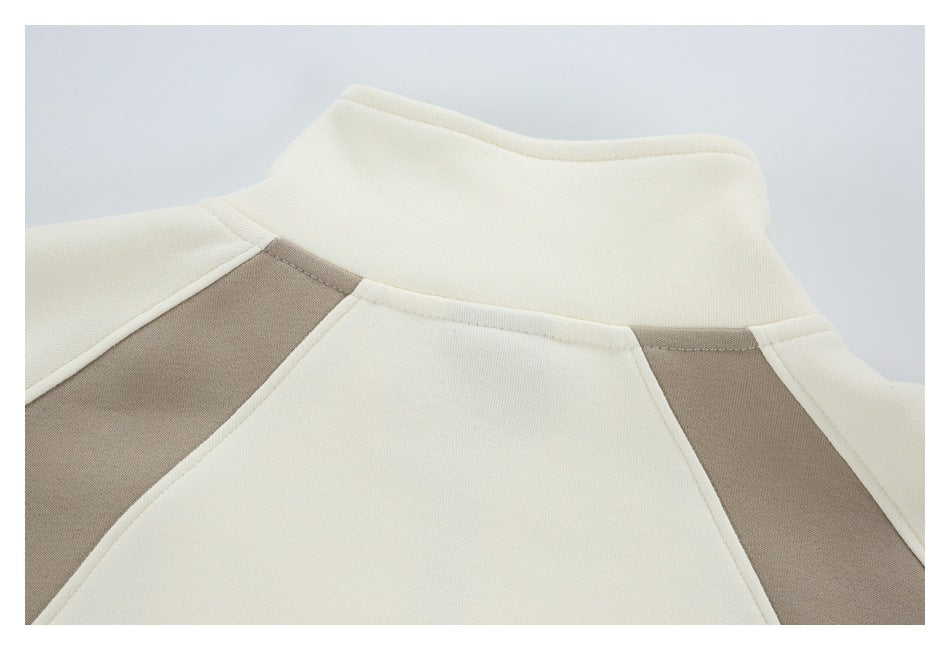 Close-up of the back collar and taupe color-block panels on a cream garment.